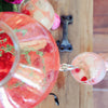 This recipe makes a shareable batch of Raspberry Thyme Lemonade (shown in a large serving container) with a glass full of the cocktail. It is garnished with fresh raspberries and thyme.