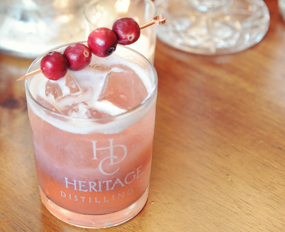 A fresh take on a whiskey sour using HDC Elk Rider Bourbon with cranberry juice and cranberry garnishes.