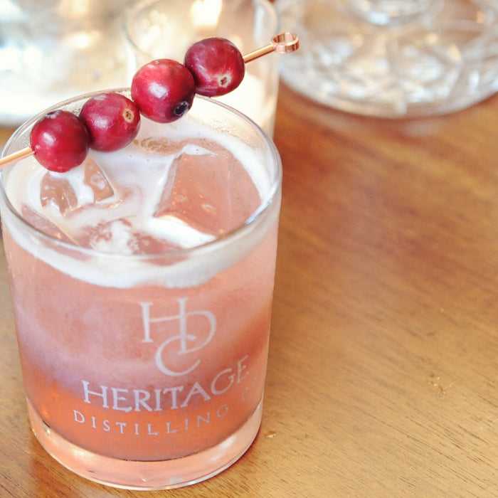 A fresh take on a whiskey sour using HDC Elk Rider Bourbon with cranberry juice and cranberry garnishes.