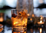 The perfect fall drink in a Heritage Distilling Co. branded tumbler features HDC Elk Rider Bourbon. It is garnished with orange peel and cranberries on top.