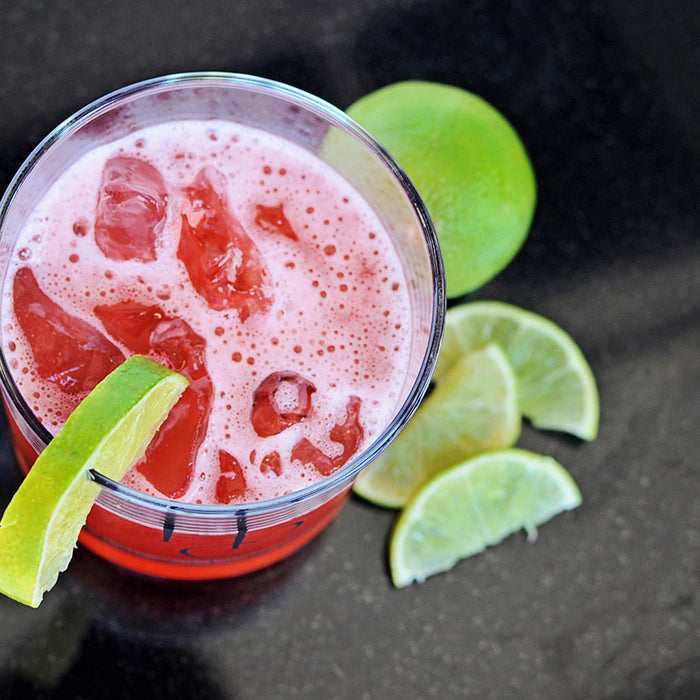 A fruit punch cocktail featuring HDC Citrus Vodka, HDC Mango Vodka, and HDC Hibiscus Vodka over ice with lime wedges.