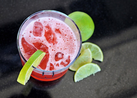 A fruit punch cocktail featuring HDC Citrus Vodka, HDC Mango Vodka, and HDC Hibiscus Vodka over ice with lime wedges.
