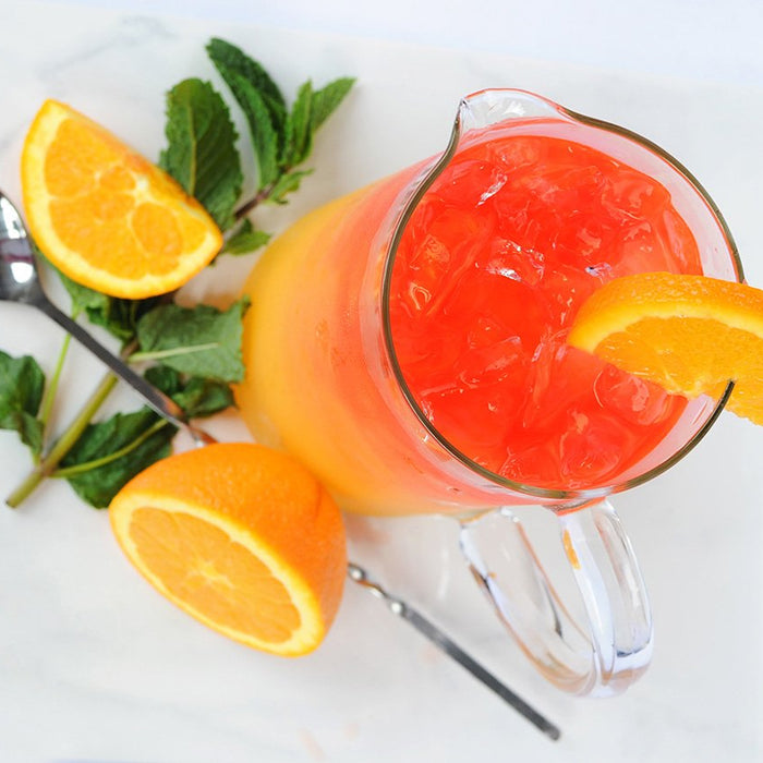 A bright yellow and orange cocktail featuring HDC Elk Rider Vodka and garnished with orange slices.