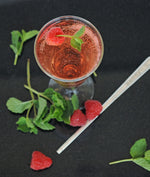 A glass with a mule using HDC Raspberry Vodka and garnished with basil leaves and raspberries.