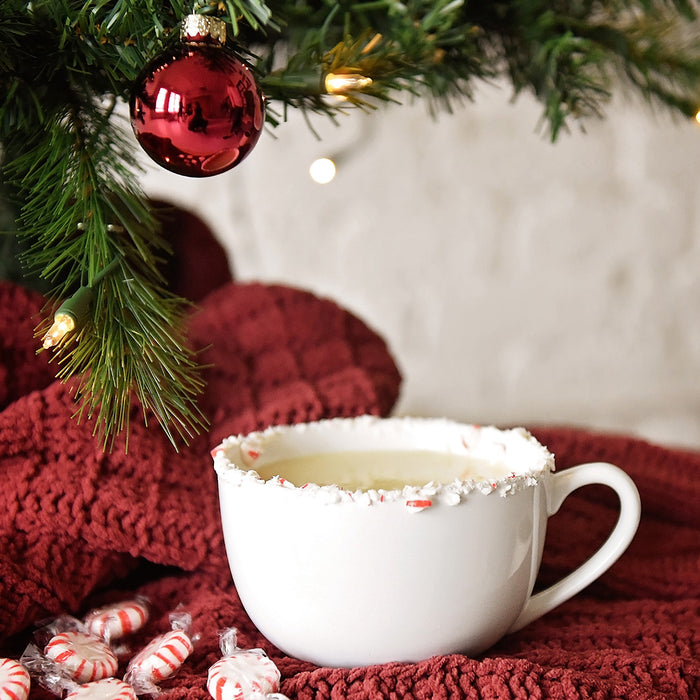 This delicious eggnog cocktail in a crushed candy cane-rimmed mug is made with HDC Vanilla Vodka and can be served hot or cold.
