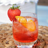 A gin fizz drink made with HDC Elk Rider Gin and garnished with orange peel and a strawberry.