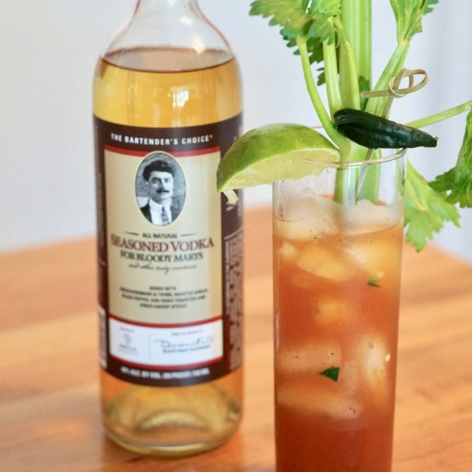 A Spicy Bloody Mary Cocktail featuring D's Seasoned Vodka and garnished with lime and celery.