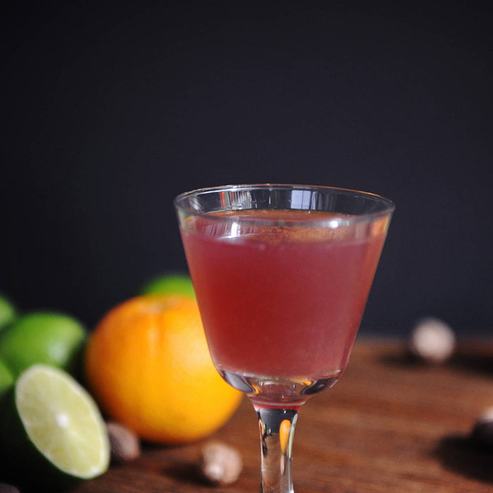 A rum cocktail that uses HDC Commander's Rum with different citrus fruits in the background.