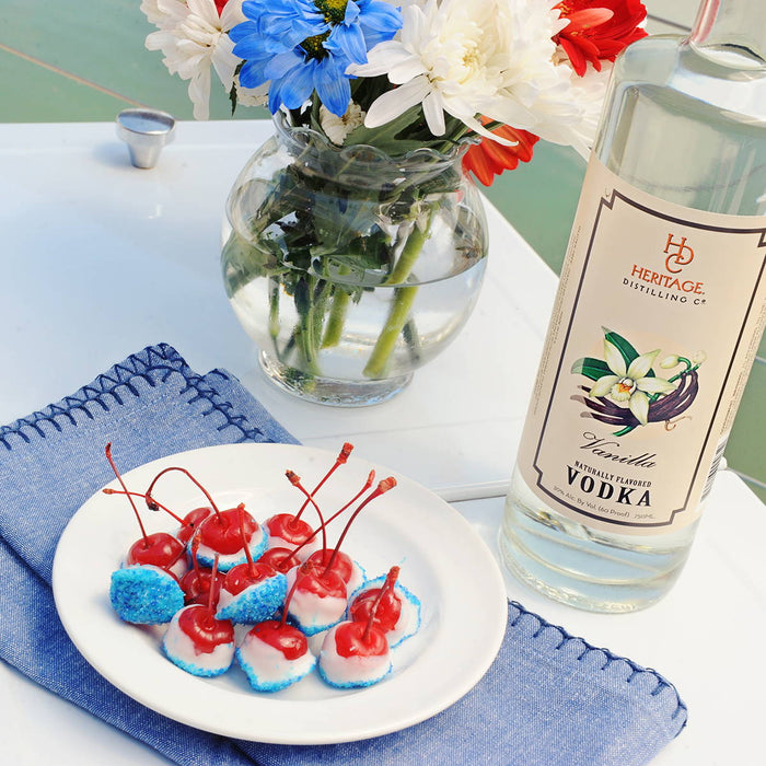 A plate full of boozy cherry bombs and a bottle of HDC Vanilla Vodka.