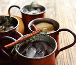There are copper mule mugs filled with apple cider mules made from BSB Brown Sugar Bourbon.