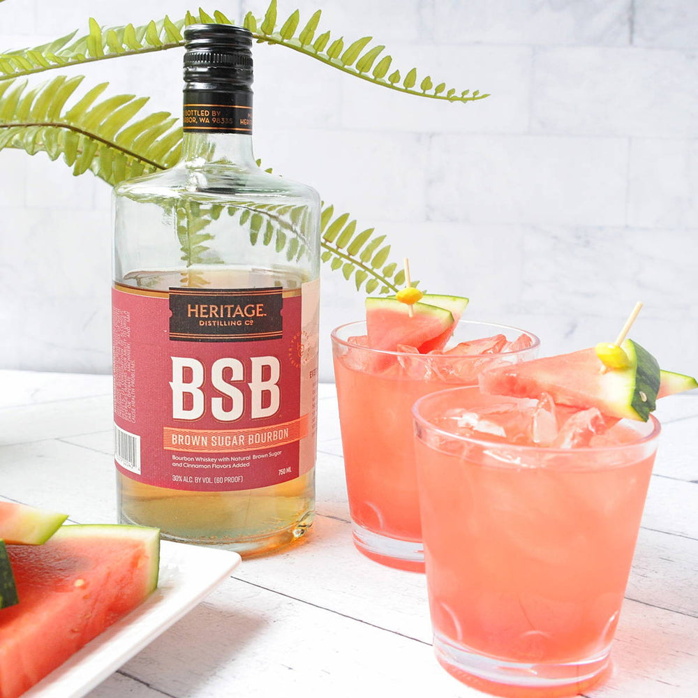 A bottle of BSB - Brown Sugar Bourbon and two full glasses of Whiskey Watermelon Punch using that BSB.