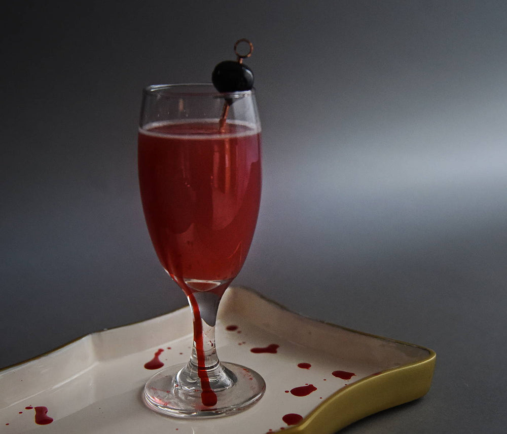 In a daisy glass, this deep red cocktail features HDC Sweet Ghost Pepper Vodka and a Luxardo Cherry garnish.
