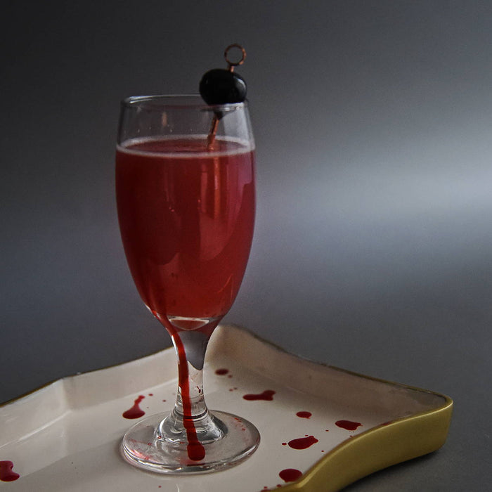 In a daisy glass, this deep red cocktail features HDC Sweet Ghost Pepper Vodka and a Luxardo Cherry garnish.