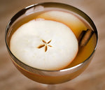 A glass filled with a cocktail using BSB 103 and garnished with both apple and cinnamon stick.