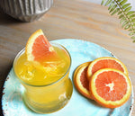 A bright yellow HDC Citrus vodka cocktail with orange wedge garnishes.