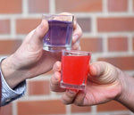 One person holding a purple shot in a shot glass (to represent the Huskies) and another person holding a red shot in a shot glass to represent the Cougs. The first is made using HDC Lavender Vodka and the second using HDC Sweet Ghost Pepper Vodka.