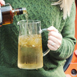 There is a woman holding a pitcher of this cocktail that uses HDC Batch No. 12 Bourbon.
