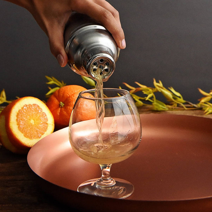 A shaker full of this BSB 103 cocktail is double-strained and poured into a goblet.