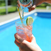 A person is topping the HDC Blood Orange Vodka off with Cran-Raspberry La Croix then garnishing it with a lime wheel.