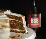 A bottle of BSB - Brown Sugar Bourbon is placed next to a thin slice of BSB Applesauce Torte.