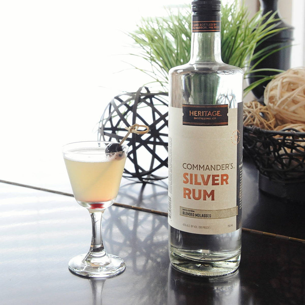 A bottle of Commander's Silver Rum and the "Seersucker" Cocktail with a Luxardo Cherry garnish.