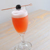 A daisy goblet with the Blood Orange Madness (using HDC Blood Orange Vodka) and garnished with a Luxardo Cherry.