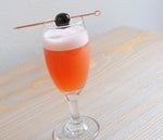 A daisy goblet with the Blood Orange Madness (using HDC Blood Orange Vodka) and garnished with a Luxardo Cherry.