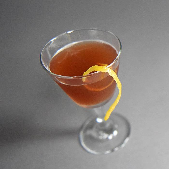 A cocktail made with HDC Coffee Vodka and garnished with a lemon peel twist.