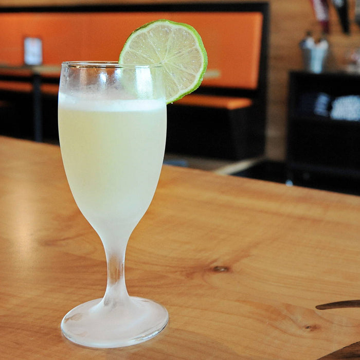 This cool gin cocktail (using either HDC Batch No. 12 Gin or HDC Elk Rider Gin) is served in a cocktail goblet with a lime wheel garnish.