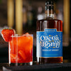 Strawberry cocktail with bottle of Cocoa Bomb Whiskey