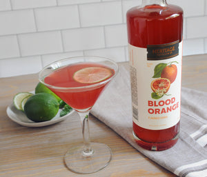 
                  
                    A 750ml bottle of HDC Blood Orange Vodka and a blood orange ginger cosmo cocktail in a martini glass.
                  
                