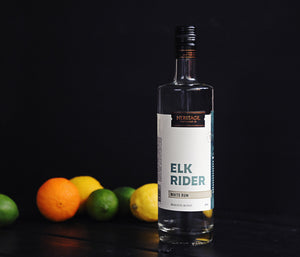 
                  
                    A 750ml bottle of Elk Rider White Rum with an orange, lemons, and limes in the background.
                  
                